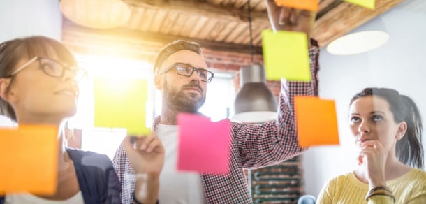 three people collaborating with sticky notes