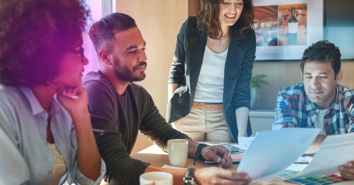 image of four people in an office looking at documents 